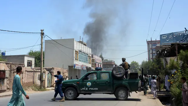 Personel keamanan Afghanistan memblokade jalan dekat ledakan bom diri di Jalalabad, Selasa (31/7). Pria bersenjata menyerang gedung pemerintahan, membuat puluhan orang terperangkap setelah pelaku meledakkan bom bunuh diri. (AFP/NOORULLAH SHIRZADA)