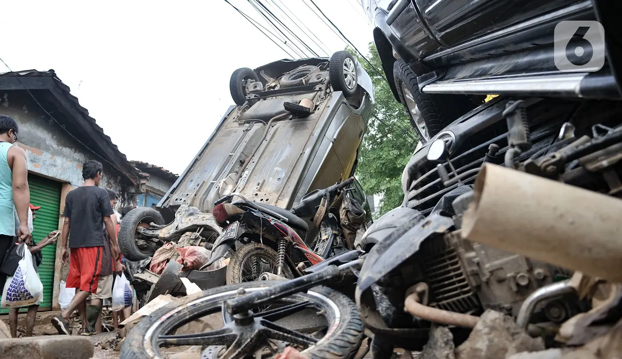 Kondisi sejumlah mobil yang terbalik akibat terjangan banjir di Perumahan Pondok Gede Permai, Jatiasih, Kota Bekasi, Jawa Barat, Kamis (2/1/2020). Derasnya terjangan banjir menyebabkan puluhan mobil terbalik dan belasan sepeda motor ringsek akibat terbawa arus. (merdeka.com/Iqbal Nugroho)
