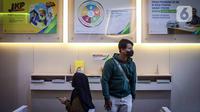 Nasabah melakukan pencairan dana Jaminan Hari Tua (JHT) di Kantor BPJS Ketenagakerjaan Cabang Sudirman, Jakarta, Selasa (15/2/2022). Nasabah masih dapat mencairkan dana JHT meski belum menginjak usia 56 tahun sebelum Permenaker Nomor 2 Tahun 2022 diberlakukan. (Liputan6.com/Faizal Fanani)