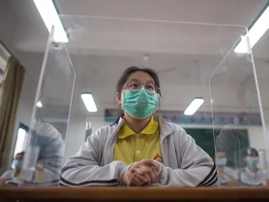 Siswa belajar dengan pemisah pada masing-masing meja mereka sebagai langkah pencegahan penyebaran COVID-19 di Sekolah Menengah No. 23 Wuhan, Wuhan, Provinsi Hubei, China, Rabu (6/5/2020). Sekitar 57.800 siswa tingkat akhir dari 121 SMA dan kejuruan di Wuhan kembali bersekolah. (Xinhua/Xiao Yijiu)