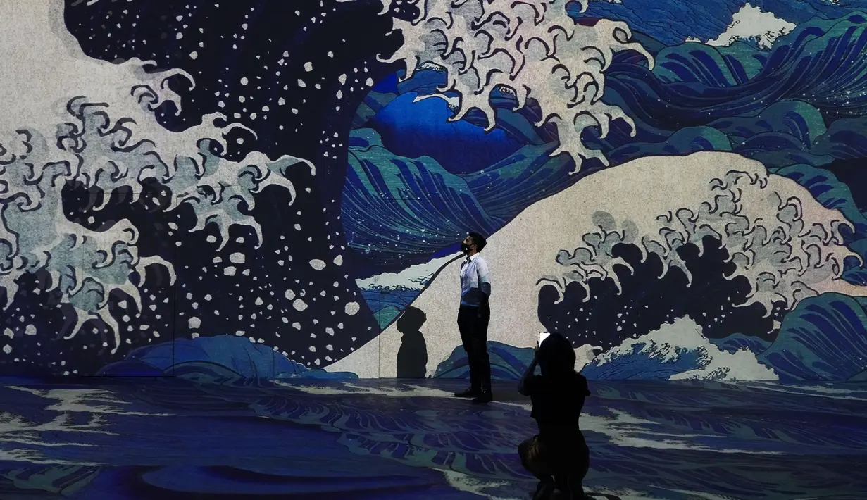Seorang pria berpose di galeri seni digital Infinity des Lumieres di Dubai Mall, Dubai, Uni Emirat Arab, Senin (12/7/2021). Infinity des Lumieres menggunakan proyektor digital untuk memutar gambar bergerak karya seni di galeri besar. (AP Photo/Jon Gambrell)