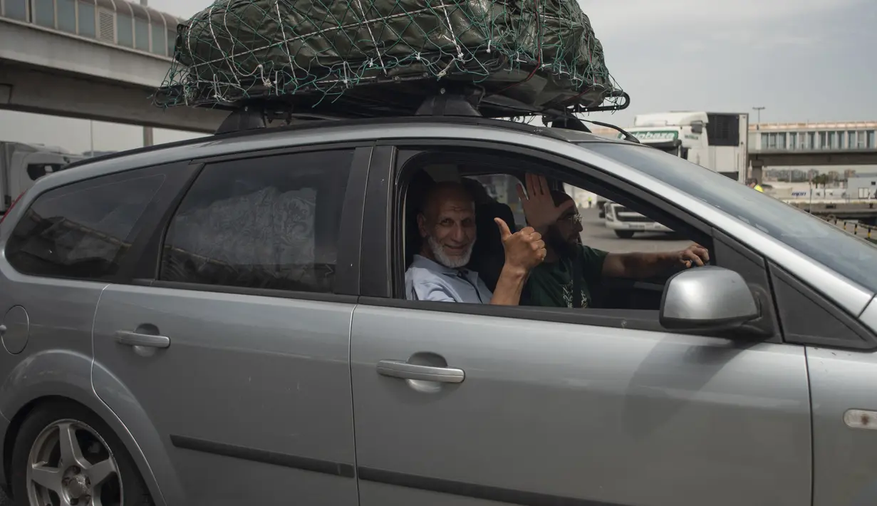 Penumpang mengacungkan jempol dari mobil mereka saat antre untuk naik feri menuju Tangier di pelabuhan Algeciras, Spanyol, Rabu (15/6/2022). Ribuan warga negara Maroko yang bekerja dan tinggal di Eropa melewati Selat Gibraltar saat mereka kembali untuk menghabiskan liburan musim panas di Maroko. (JORGE GUERRERO / AFP)