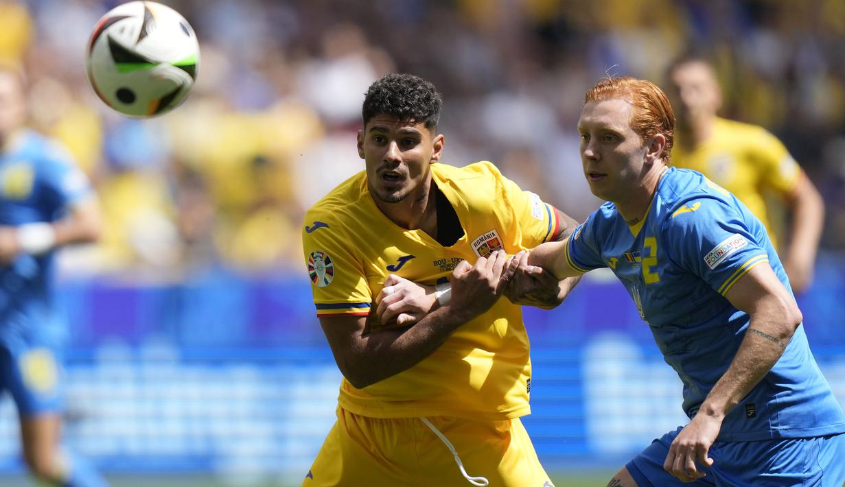 Striker Timnas Rumania, Florinel Coman (kiri) berebut bola dengan bek Timnas Ukraina, Yukhym Konoplia pada laga Grup E Euro 2024 di Allianz Arena, Munchen, Jerman, Senin (17/6/2024). (AP Photo/Matthias Schrader)