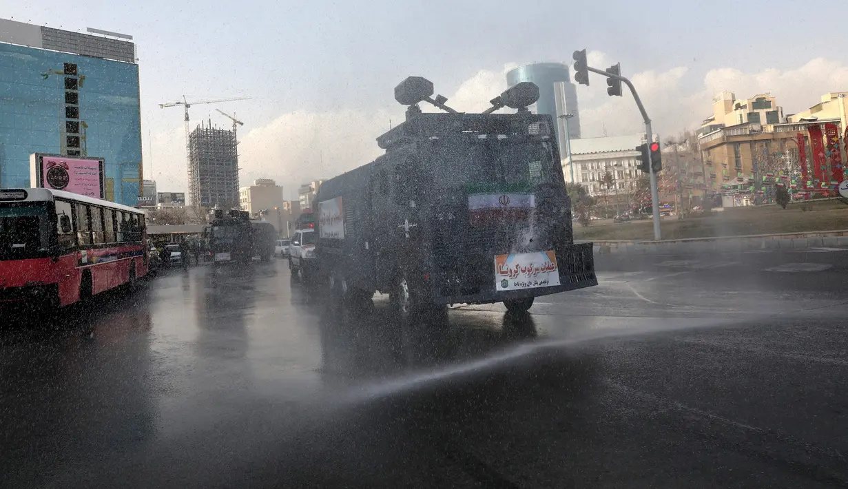 Kendaraan Water Canon kepolisian menyempotkan desinfektan untuk mensterilkan jalan-jalan di Teheran, 1 Maret 2020. Kasus virus corona di Iran mengalami lonjakan tajam dalam beberapa hari dan tercatat memiliki korban meninggal tertinggi setelah China, yang menjadi pusat wabah. (AP Photo/Vahid Salemi)