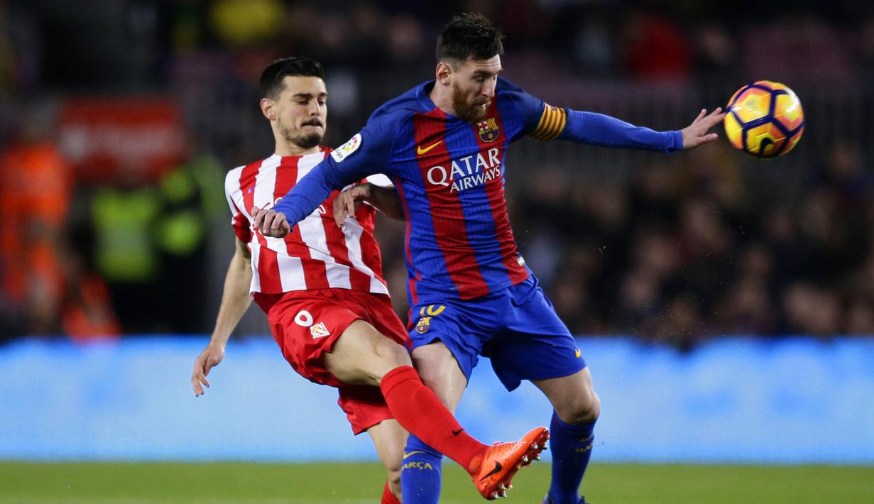 Bintang Barcelona, Lionel Messi, berusaha melewati gelandang Sporting, Sergio Alvarez. Bermain di kandang, La Blaugrana menunjukan dominasinya dengan penguasaan bola mencapai 72 persen. (AP/Manu Fernandez)