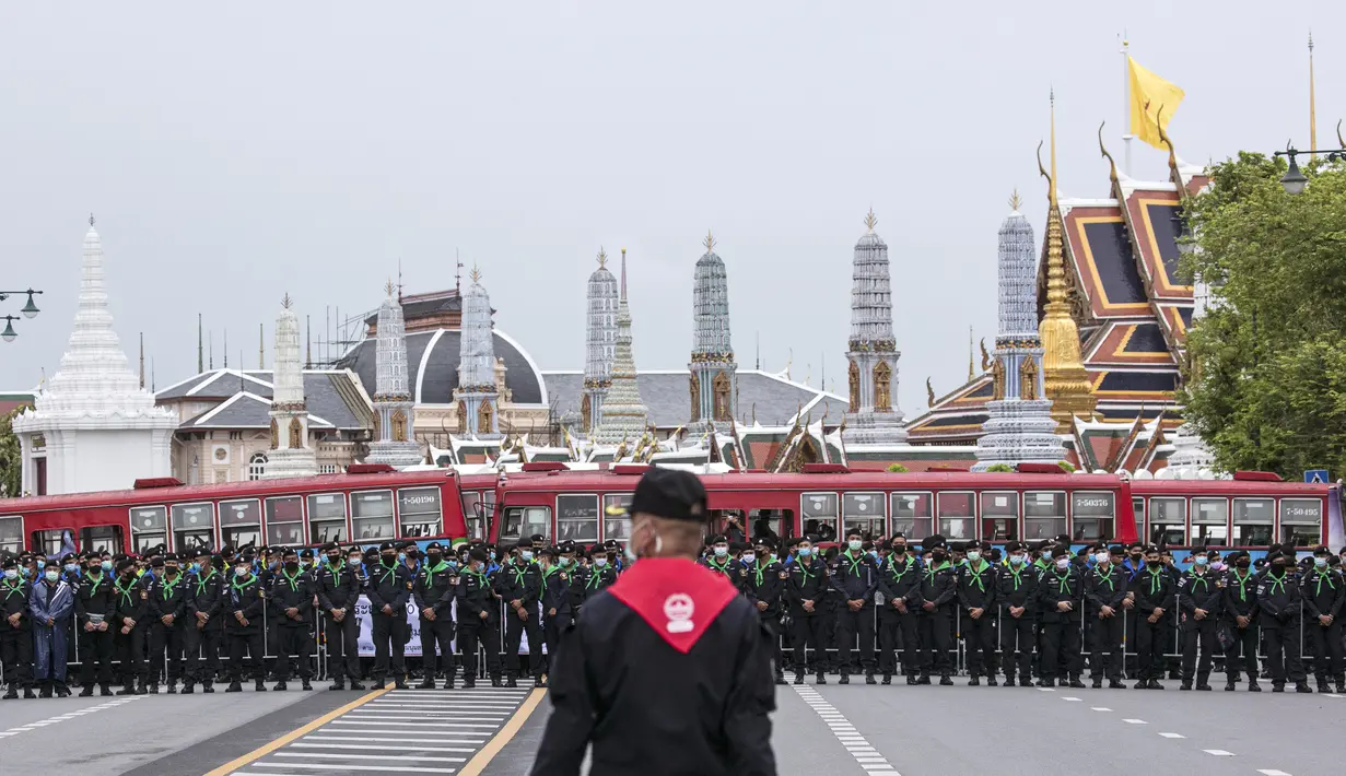 Petugas polisi yang mengenakan masker wajah berdiri dalam antrean, melindungi kawasan di sekitar Grand Palace selama protes di Bangkok, Thailand, Minggu (20/9/2020). (AP Photo/Wason Wanichakorn)