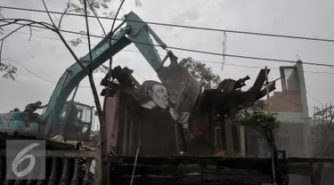 Ekskavator meratakan Sanggar Saung Merdeka Ciliwung Bukit Duri, Jakarta, Rabu (28/9). Penghuni sanggar dan sejumlah warga mulai memainkan angklung, memukul kaleng dan panci sambil menatap sanggar tersebut runtuh. (Liputan6.com/Yoppy Renato)