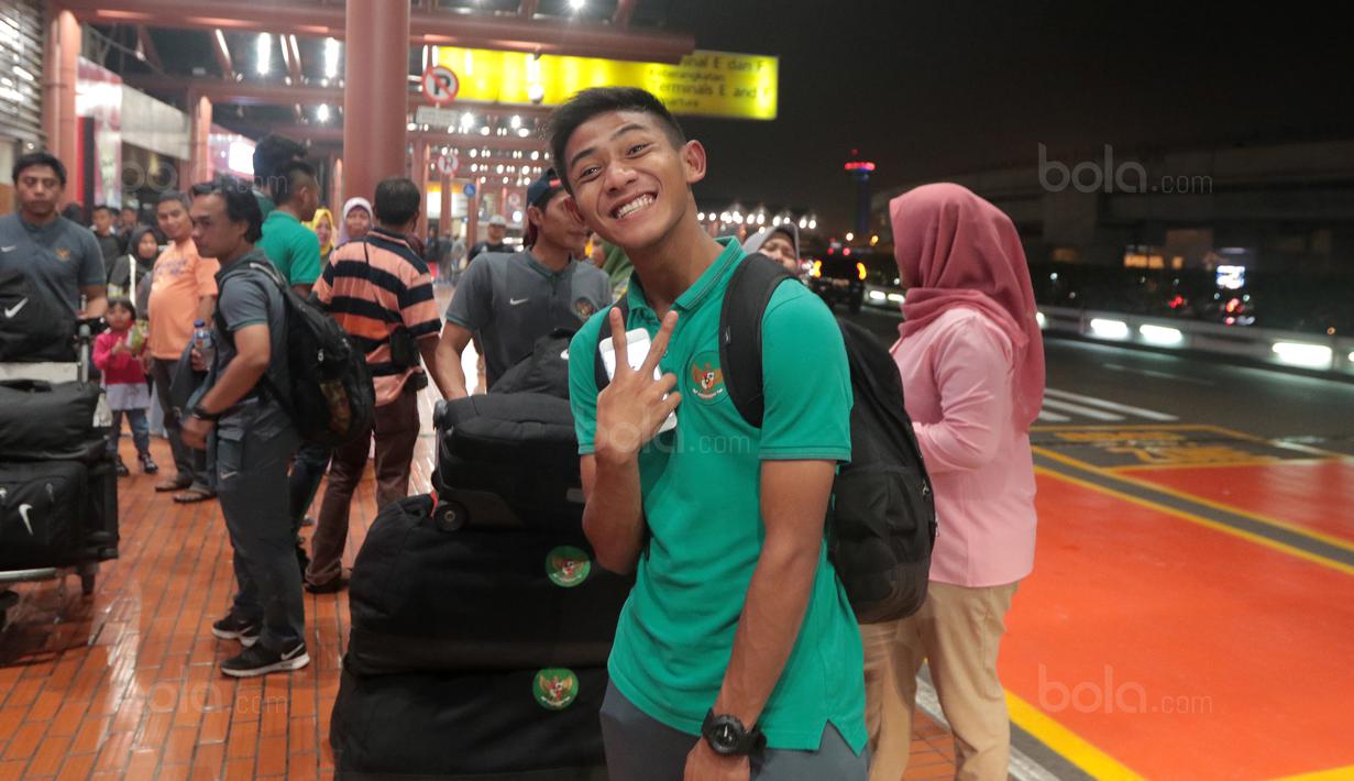 Senyum Pemain Timnas U-19, Firza Andika saat bersiap melakukan check in di Bandara Soekarno-Hatta, Cengkareng, (28/10/2017). Timnas U-19 akan mengikuti kualifikasi Piala Asia di Korea Selatan. (Bola.com/Nicklas Hanoatubun)