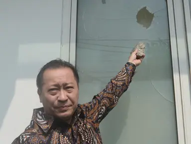 Wakil Ketua Umum PPP, Humphrey R Djemat menunjukkan kaca kantor DPP PPP di Jalan Diponegoro, Jakarta Pusat yang pecah akibat aksi penyerangan, Minggu (16/7). Kantor DPP PPP diserang puluhan orang tak dikenal dini hari tadi. (Liputan6.com/Herman Zakharia)
