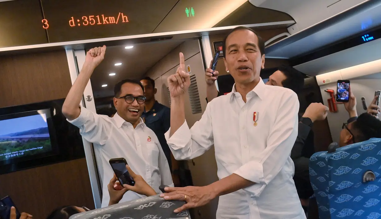 Presiden Indonesia Joko Widodo (kanan) dan Menteri Perhubungan Budi Karya Sumadi (kiri) menunjuk ke arah layar yang menunjukkan kecepatan saat uji coba kereta cepat Jakarta-Bandung di Jakarta pada 13 September 2023. (Akbar Nugroho Gumay/Antara Foto/AFP)