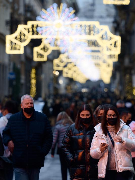Pejalan kaki melintas di jalan perbelanjaan Roma, Italia pada Kamis (23/12/2021). Pemerintah Italia telah mewajibkan kembali penggunaan masker di luar ruangan untuk menahan peningkatan kasus Covid-19 yang didorong oleh varian Omicron. (Filippo MONTEFORTE/AFP)