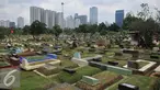Warga melewati area makam TPU Karet Bivak, Jakarta (2/2). Dinas Pertamanan dan Pemakaman DKI telah menerapkan sistem online dalam pelayanan pemakaman di Ibukota dengan alamat situs pertamananpemakaman.jakarta.go.id. (Liputan6.com/Gempur M Surya)