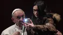Seorang anak perempuan tidak mau ketinggalan berfoto selfie dengan Paus Fransiskus dalam kunjungannya ke St Mary Josefa di Roma, Italia, Minggu (19/2). (AFP Photo/TIZIANA FABI)