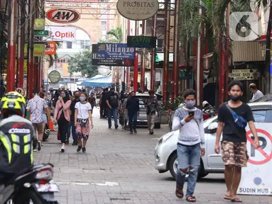 Sejumlah orang mengenakan masker saat berada di Pasar Baru, Jakarta Pusat, Selasa (9/6/2020). Pusat perbelanjaan tersebut kembali dibuka, meski masih dalam masa Pembatasan Sosial Berskala Besar (PSBB) transisi. (Liputan6.com/Angga Yuniar)