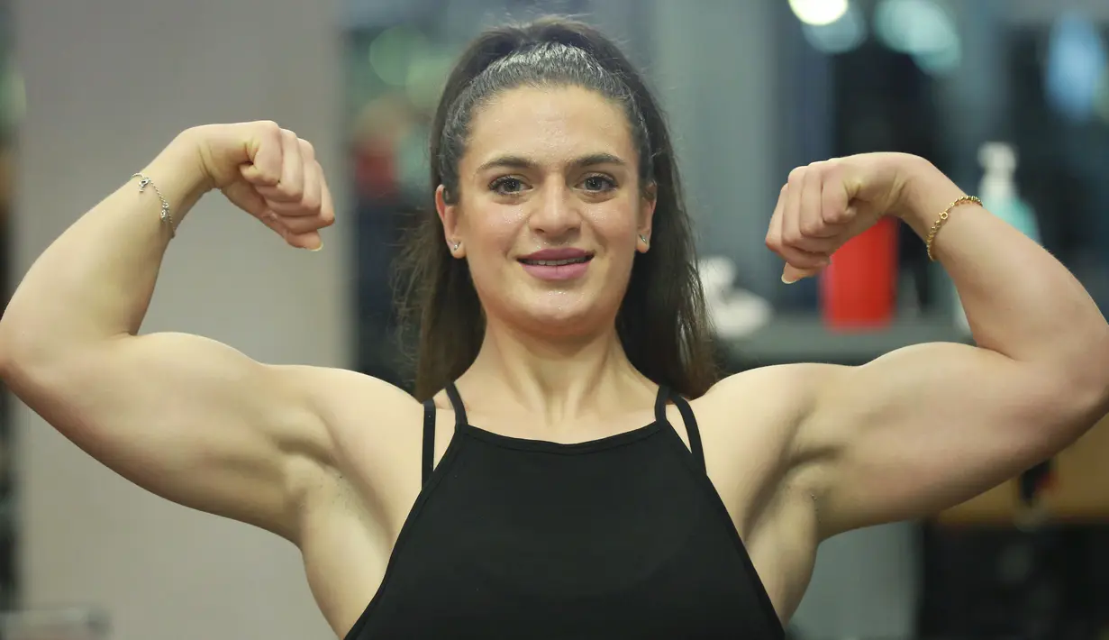 Binaragawan Yordania, Dana Sombouloglu menunjukkan ototnya selama sesi latihan di gym di ibukota Amman, pada 29 Januari 2020. Perempuan 26 tahun ini memiliki tekad kuat untuk membuktikan bahwa perempuan Yordania bisa jadi binaragawan. (AFP/Khalil Mazraawi)