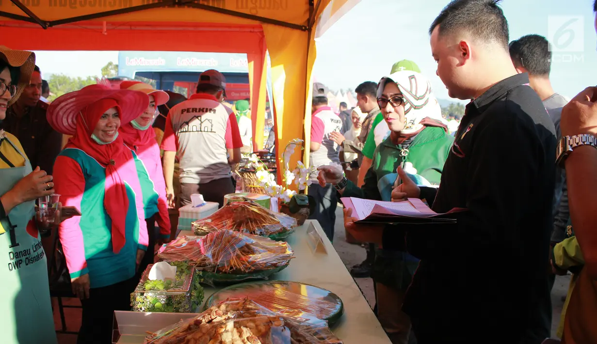 Ketua PKK Fory Naway, Ketua Panitia FPDL Hen Restu Tanjung bersama tim dari Rekor MURI menilai sebanyak 88.950 tusuk sate yang disajikan untuk memeriahkan Festival Pesona Danau Limboto, Gorontalo, Senin (24/9). (Liputan6.com/Arfandi Ibrahim)