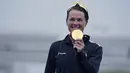 Atlet Bermuda, Flora Duffy memegang medali emasnya saat seremoni kompetisi triathlon nomor individu putri Olimpiade Tokyo 2020 di Odaiba Marine Park, Selasa (27/7/2021). Flora Duffy menjadi penyumbang medali emas untuk negara berpenduduk 60 ribu orang itu. (AP/David Goldman)