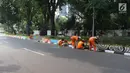 Petugas PPSU Gondangdia mengecat pembatas jalan dengan warna-warni Asian Games di kawasan Menteng, Jakarta, Kamis (12/7). Cat lukisan dinding beraneka gambar dan bentuk untuk menyambut HUT kemerdekaan RI dan Asian Games 2018. (Liputan6.com/Arya Manggala)