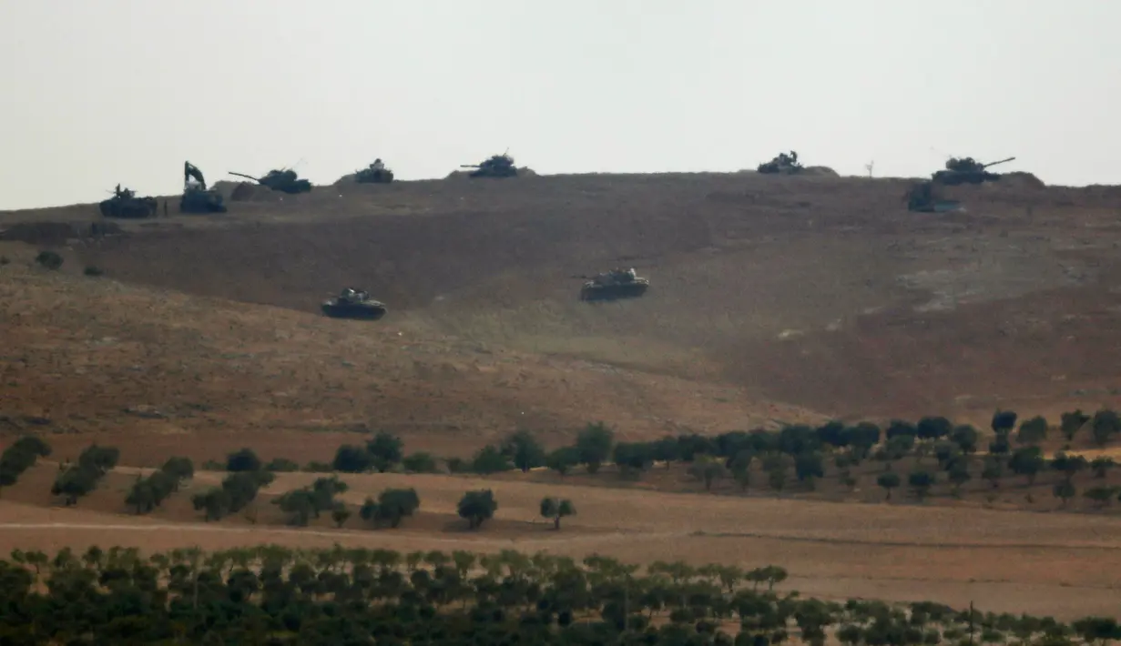 Tank tentara Turki berjaga di sebuah bukit Jarablus kota di Suriah yang terletak dekat perbatasan antara Turki-Suriah (24/8). Turki menambah belasan tank ke Suriah untuk membantu militer lainnya mengusir ISIS. (REUTERS/Umit Bektas)