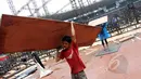 Pekerja membongkar penutup rumput (grass cover) usai konser One Direction di Stadion Utama Gelora Bung Karno (SUGBK), Jakarta, Kamis (26/3/2015). Lapangan SUGBK akan dipersiapkan untuk Pra-Piala Asia U-23. (Liputan6.com/Helmi Afandi)