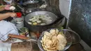 Ide pengembangan keripik tempe bermula dari pengalaman Tina saat berkunjung ke Magelang, Jawa Tengah. Tampak dalam foto, pekerja menyelesaikan pembuatan keripik tempe di rumah usaha Keripik Tempe Mama Tina, Kebayoran Baru, Jakarta Selatan, Kamis (7/5/2026). (merdeka.com/Arie Basuki)