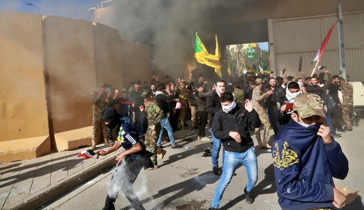 Tentara AS menembakkan gas air mata ke arah demonstran yang masuk ke kompleks kedutaan AS, di Baghdad, Irak (31/12/2019). Serbuan ini dilakukan para demonstran yang marah atas serangan udara AS terhadap milisi Irak yang disebut pro-Iran. (AP Photo/Khalid Mohammed)