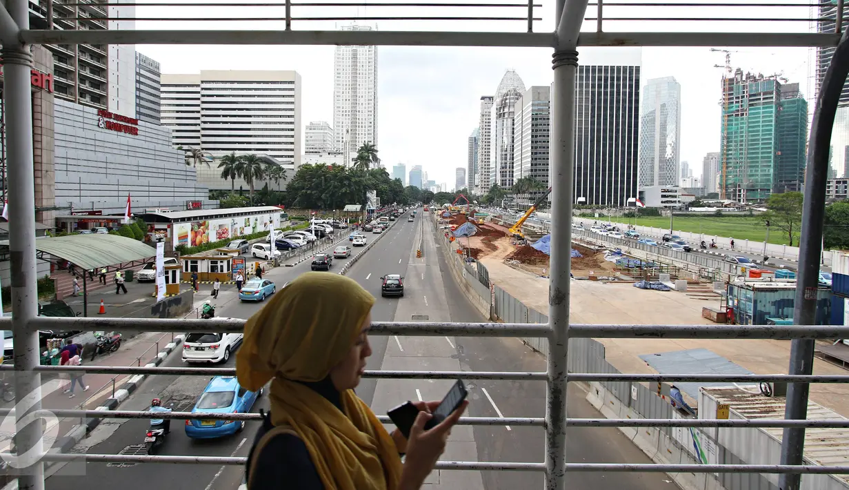 Pejalan kaki berjalan di halte Transjakarta di Jalan Sudirman, Jakarta, Senin (2/5). Mulai tahun ini, Pemprov DKI Jakarta akan menata jalan, trotoar, dan taman di kawasan Sudirman-Thamrin. (Liputan6.com/Immanuel Antonius)