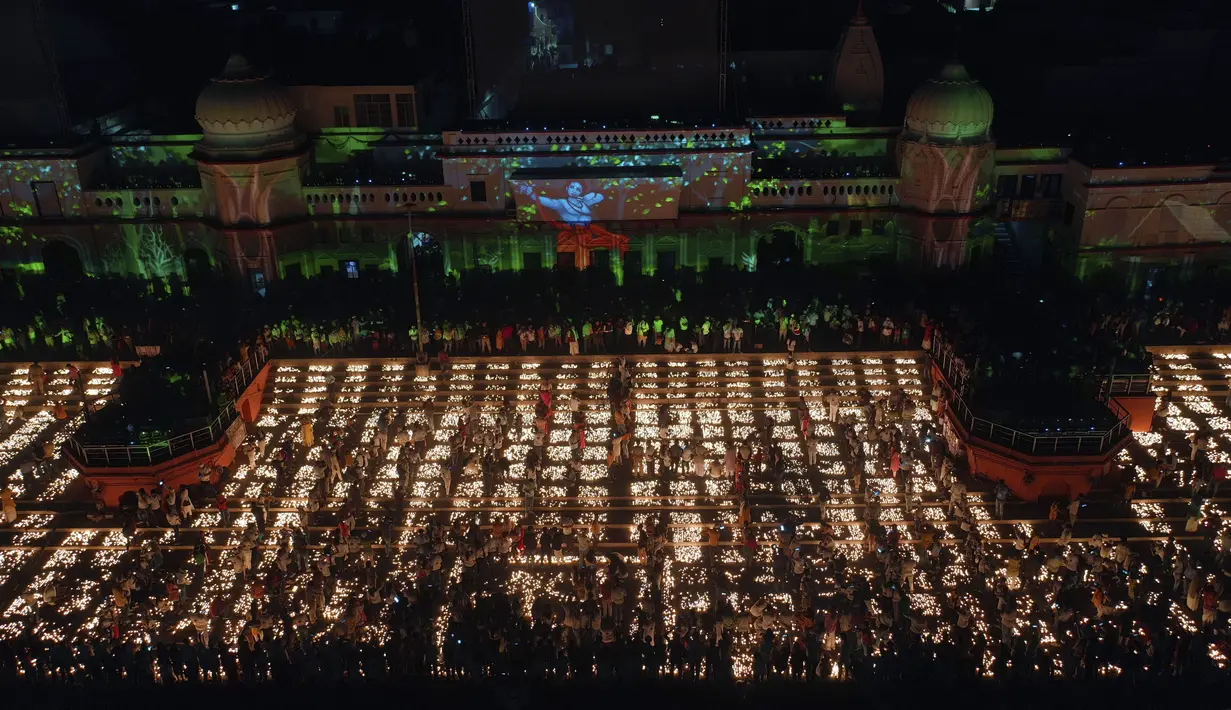 Orang-orang menyalakan lampu di tepi sungai Saryu di Ayodhya, India, Rabu (3/11/2021). Lebih dari 900.000 lampu minyak dinyalakan dan terus menyala selama 45 menit saat kota Ayodhya mempertahankan Rekor Dunia Guinness sebagai bagian dari perayaan festival Diwali. (AP Photo/Rajesh Kumar Singh)