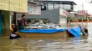 Warga mengevakuasi barang-barangnya saat banjir melanda Perumahan Total Persada, Periuk, Kota Tangerang, Selasa (4/2/2020). Banjir akibat tanggul kali Ledug jebol membuat ratusan rumah di Total Persada terendam banjir hingga mencapai 3,5 meter. (merdeka.com/Arie Basuki)