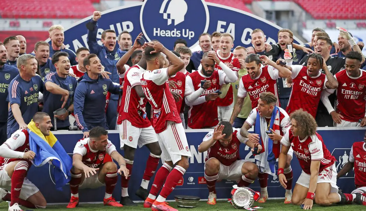 Ekspresi para pemain Arsenal ketika Piala FA terjatuh saat perayaan gelar juara di Stadion Wembley, London, Minggu (2/8/2020). Arsenal menjadi Juara Piala FA setelah menaklukkan Chelsea dengan skor 2-1. (Adam Davy/Pool via AP)