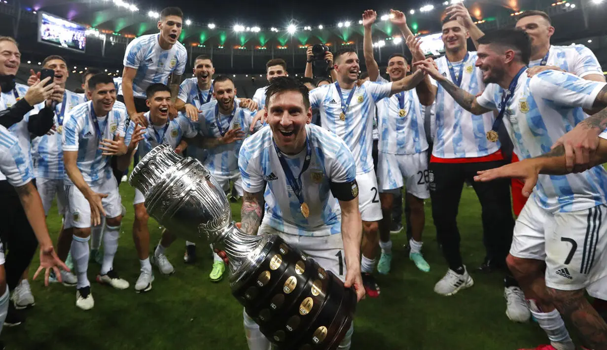 Penyerang  Argentina, Lionel Messi merayakan trofi  Copa America 2021 bersama rekannya usai mengalahkan Brasil 1-0 dalam pertandingan final di stadion Maracana, Brasil, Minggu (11/7/2021). Inilah kali pertamanya  Messi mempersembahkan trofi juara bagi Albiceleste. (AP Photo/Bruna Prado)