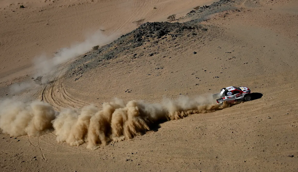 Pembalap Toyota Gazoo Racing Frenando Alonso dan Marc Coma bersaing pada stage pertama Reli Dakar 2020 antara Jeddah dan Al Wajh, Arab Saudi, Minggu (5/1/2020). Alonso mencetak sejarah sebagai juara dunia Formula 1 (F1) pertama yang berlaga di ajang Reli Dakar. (FRANCK FIFE/AFP)