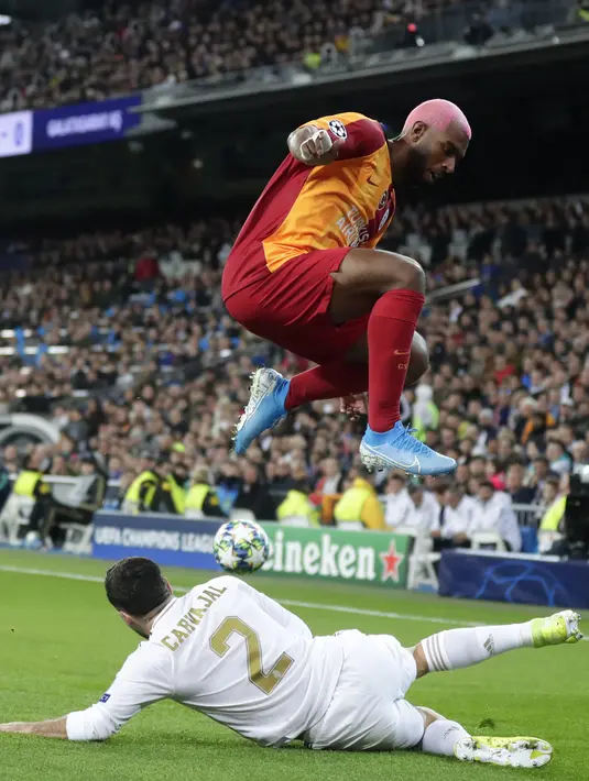 Gelandang Galatasaray, Ryan Babel berusaha melewati bek Real Madrid, Dani Carvajal pada pertandingan Grup A Liga Champions di stadion Santiago Bernabeu, Spanyol (6/11/2019). Madrid menang telak 6-0 atas Galatasaray. (AP Photo/Manu Fernandez)