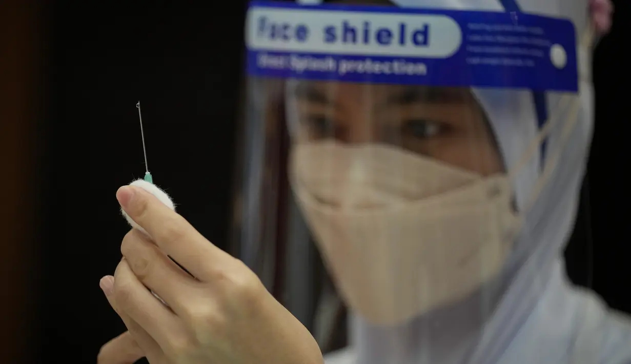 Seorang Perawat menyiapkan dosis vaksin Pfizer terhadap penyakit coronavirus (COVID-19) untuk siswa sekolah menengah di pusat vaksin di Shah Alam, Malaysia, Senin (20/9/2021). (AP Photo/Vincent Thian)