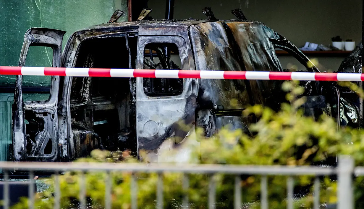 Sebuah mobil van hangus setelah menabrak pintu depan gedung tempat surat kabar ternama Belanda, De Telegraaf di Amsterdam, Selasa (26/6). Meski tak menimbulkan korban, namun aksi tabrakan itu menyebabkan kerusakan pada gedung. (KOEN VAN WEEL/ANP/AFP)