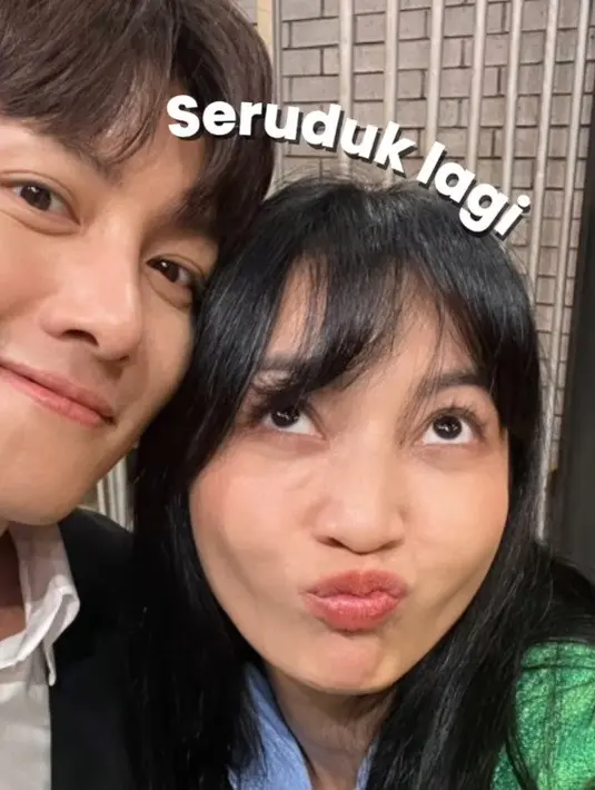 Ia tampil mengenakan seragam birunya yang khas di Lapor Pak! dengan padu padan sweater hijau. [Foto: Instagram/hestipurwadinata]