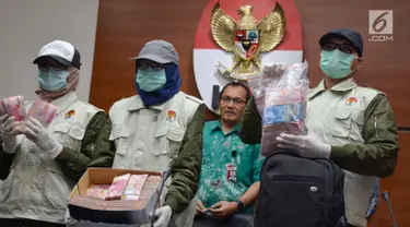 Petugas menunjukkan barang bukti uang hasil OTT di Bengkulu, ketika konferensi pers di KPK, Jakarta, Rabu (21/6). KPK menyita uang Rp 1 miliar dalam kardus di rumah Gubernur Bengkulu Ridwan Mukti saat operasi tangkap tangan.  (Liputan6.com/Helmi Afandi)