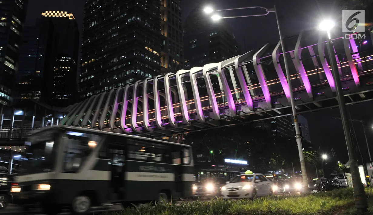 Kendaraan melintas di bawah jembatan penyeberangan orang (JPO) Gelora Bung Karno (GBK), Jakarta, Senin (25/2).   JPO GBK memiliki keunikan dalam segi arsitektur dan keindahan gemerlap lampu pada malam hari. (Merdeka.com/Iqbal S Nugroho)