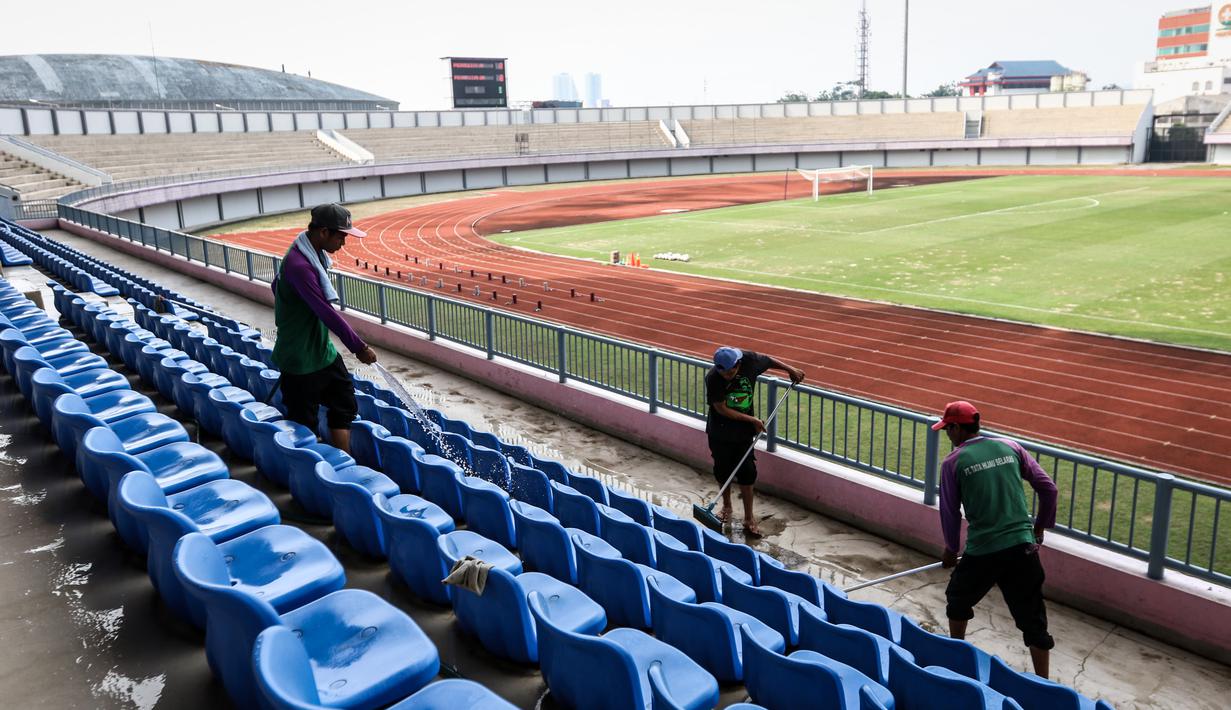 Sejumlah pekerja sedang membersihkan bangku penonton di Stadion Indomilk Arena, Tangerang pada Rabu (25/08/2021) sore WIB. Hal tersebut merupakan salah satu bentuk perawatan dan persiapan stadion untuk menyambut kompetisi BRI Liga 1 yang akan segera bergulir. (Foto: Bola.com/Bagaskara Lazuardi)