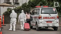 Tenaga kesehatan mengantarkan salah seorang pasien untuk menjalani perawatan di RSDC Pasar Rumput, Jakarta, Senin (2/8/2021). Sebanyak 466 pasien masih menjalani rawat inap di Rusun Pasar Rumput, angka ini menurun dari hari sebelumnya yakni 494 orang. (merdeka.com/Iqbal S Nugroho)