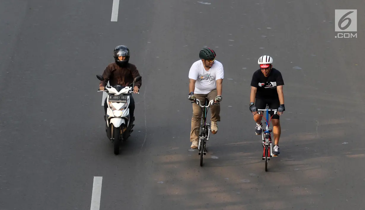 Sepeda motor melintas saat warga tengah berolahraga di kawasan Jalan Jenderal Sudirman hingga Jalan Thamrin, Jakarta, Minggu (17/6). Meski HBKB atau CFD ditiadakan, sebagian warga tetap berolahraga di kawasan ini. (Liputan6.com/Arya Manggala)
