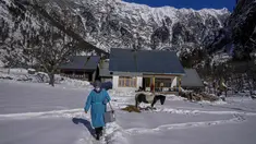 Masrat Farid, seorang petugas kesehatan, membawa vaksin saat berjalan di lapangan tertutup salju setelah memberikan dosis kepada gadis-gadis muda selama upaya vaksinasi COVID-19 di Gagangeer, timur laut Srinagar, Kashmir yang dikuasai India, pada 12 Januari 2022. (AP Photo /Dar Yasin)