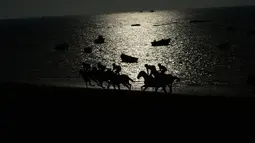Sileut peserta lomba pacuan kuda pantai tahunan di Sanlucar de Barrameda, dekat Cadiz, Spanyol (17/8). Dalam perlombaan ini peserta harus beradu cepat melintasi jalur pacu sepanjang 1400 meter. (AFP Photo/Cristina Quicler)