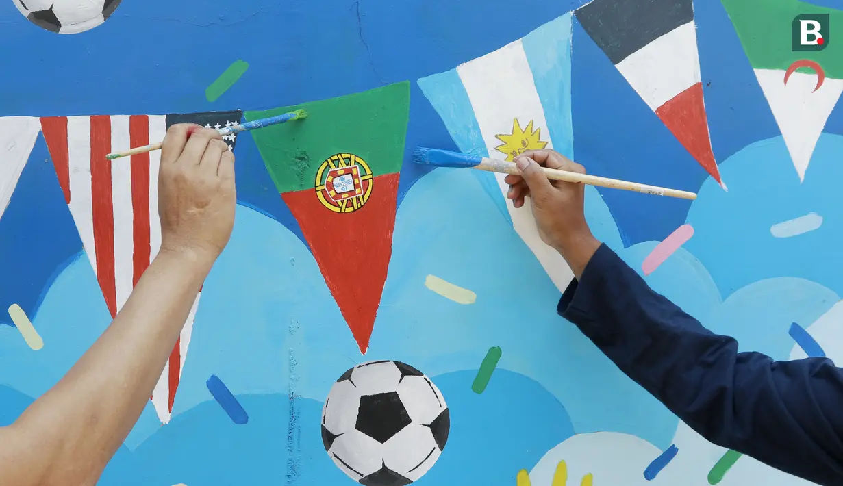 Warga menyelesaikan pembuatan mural bertema Piala Dunia 2022 di Perum Depok Maharaja Blok M1 Cluster Cemara, Rangkapan Jaya, Depok, Jawa Barat, Minggu (30/10/2022). (Bola.com/M Iqbal Ichsan)