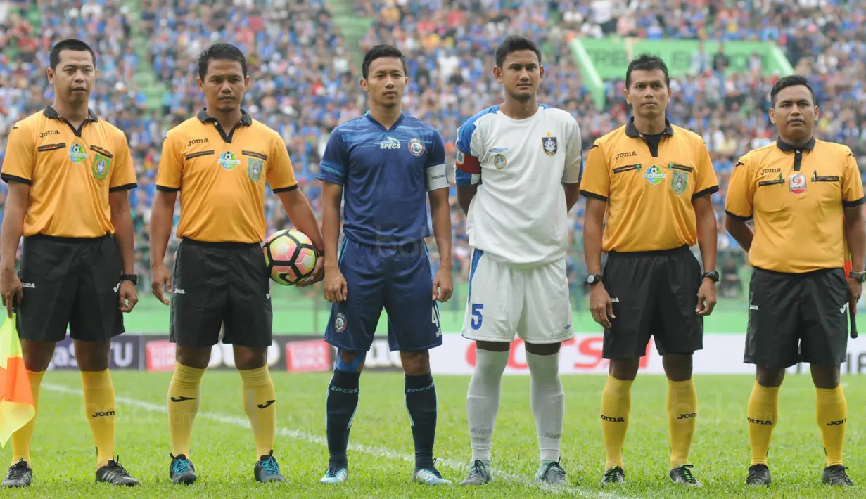 Kapten baru Arema FC, Dendi Santoso, foto bersama kapten PSIS dan wasit sebelum laga uji coba di Stadion Gajayana, Malang, Kamis (4/1/2018). Arema FC menang 5-3 atas PSIS. (Bola.com/Iwan Setiawan)