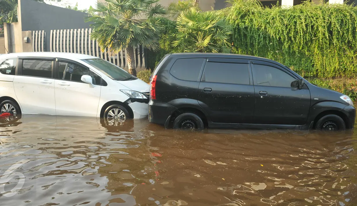 Mobil milik warga terendam banjir yang menggenangi kawasan Perumahan Pantai Mutiara, Jakarta, (4/6). Tingginya pasang air laut menyebabkan tanggul di Jalan Mutiara 1, Pluit, Penjaringan, sepanjang sekitar 50 meter jebol. (Liputan6.com/Gempur M Surya)