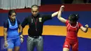 Pegulat putri Kaltim, Inadrah (kanan) mengangkat tangan usai memastikan menang melawan pegulat Sumbar Mardiatul di final gaya bebas kelas 53 kg putri pada PON XIX di Arena Saparua Sport Park, Bandung, Sabtu (24/9). (Liputan6.com/Helmi Fithriansyah)