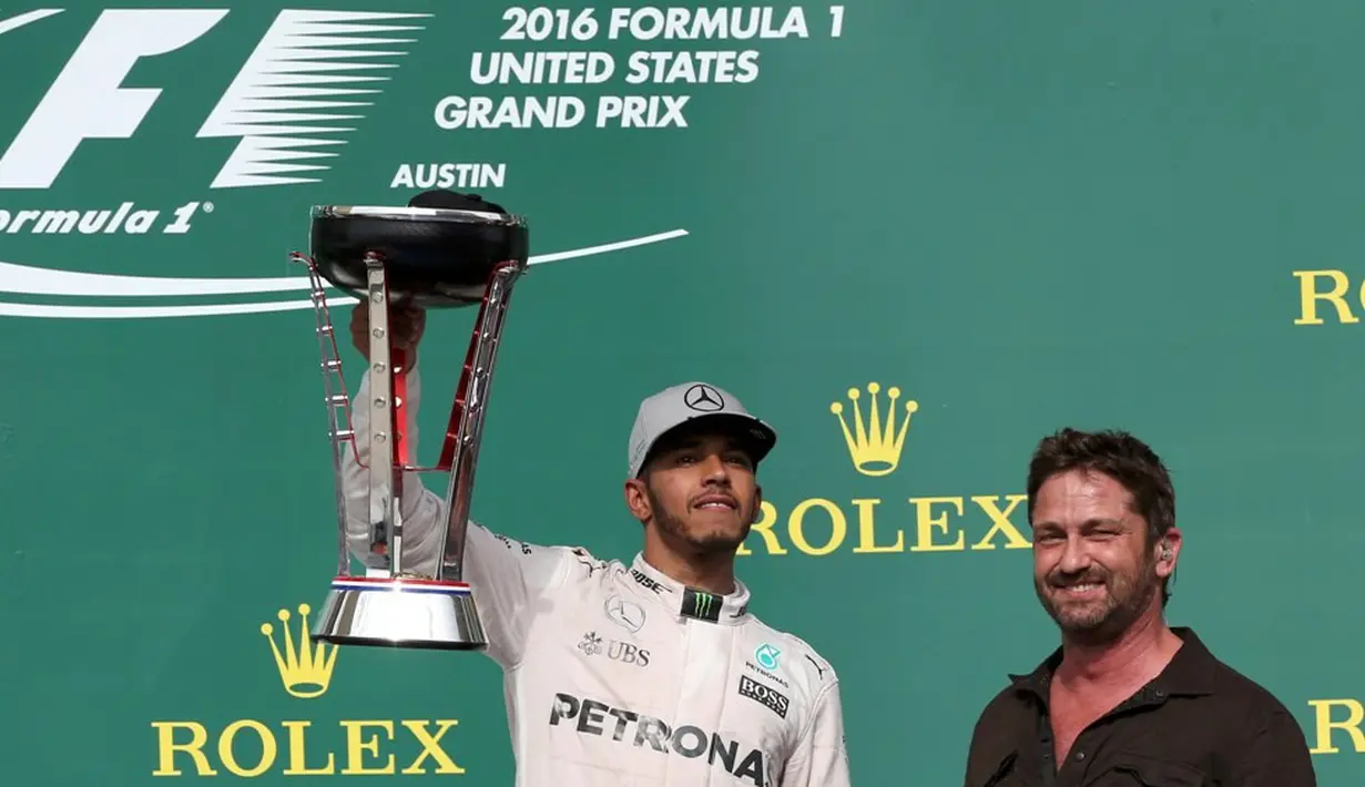 Pebalap Mercedes, Lewis Hamilton, berpose dengan trofi juara F1 GP Amerika Serikat di Sirkuit Americas, Austin, Senin (24/10/2016) dini hari WIB. (Reuters/Adrees Latif)