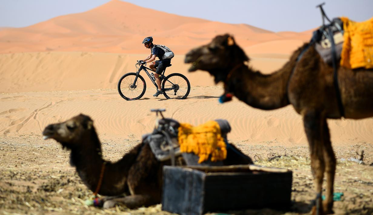 Pebalap mengendarai sepeda saat sesi latihan balap sepeda gunung Titan Gurun 2019 di sekitar Kota Merzouga, Maroko, Sabtu (27/4/2019). Trek Titan Gurun 2019 sepanjang 640 km menghubungkan antara Merzouga dan Maadid. (Franck Fife / AFP)