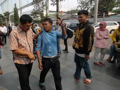 Petugas dari Polsek Senen menangkap seorang calo tiket kereta api di Stasiun Senen, Jakarta, Senin (29/6/2015). Razia tersebut dilakukan untuk mengamankan stasiun dari para calo yang merugikan calon penumpang. (Liputan6.com/Faizal Fanani) 